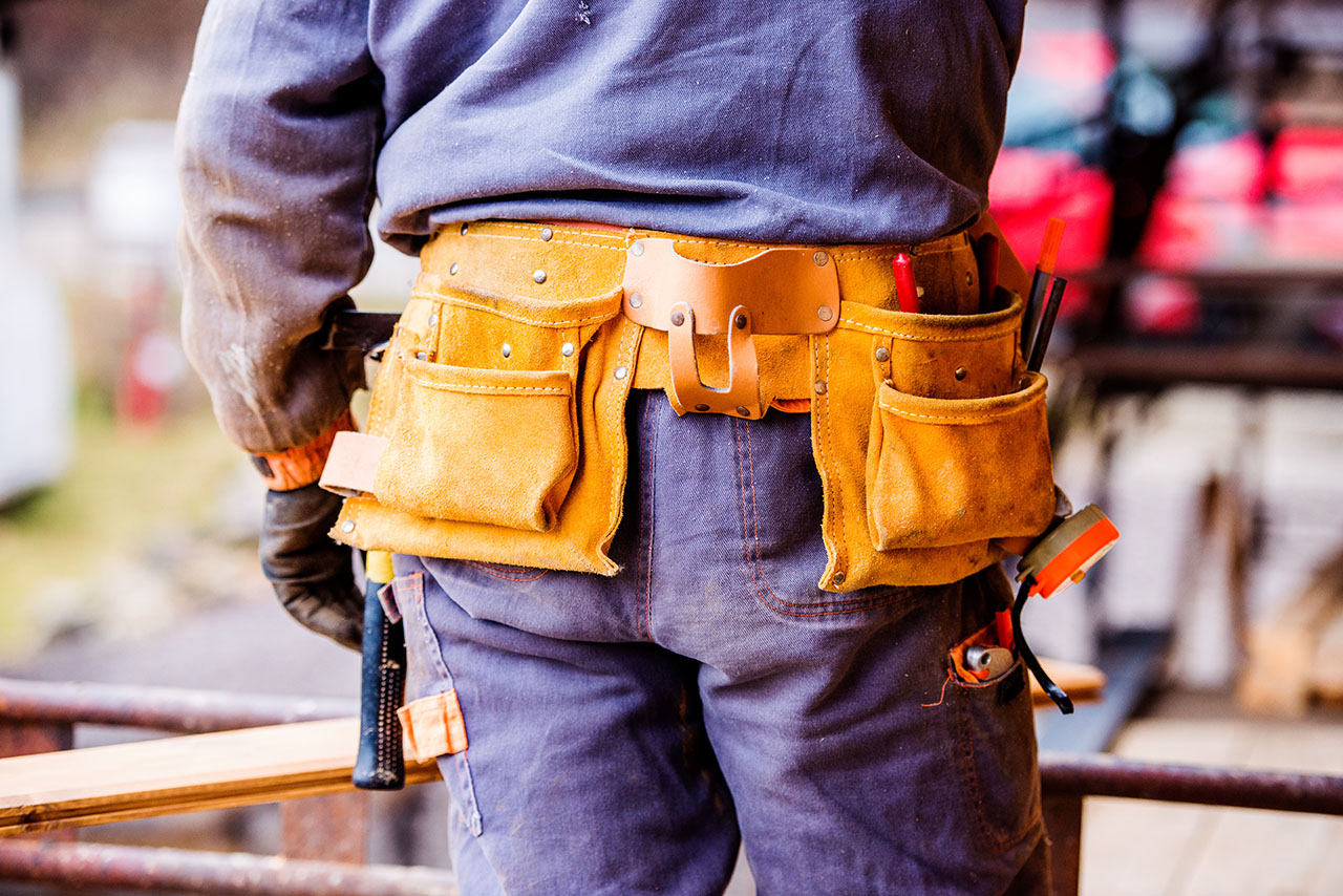 Close-up of construction worker with tool bag, rear view